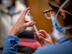Close up image of female nursing student filling a syringe.