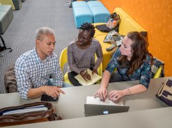 Nursing students in the School of Nursing lobby discussing an assignment.