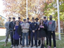 Students and Veterans posing for a photo at a flag raising.