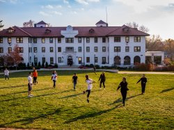 Students playing Frisbee in the quad outside of College Hall.