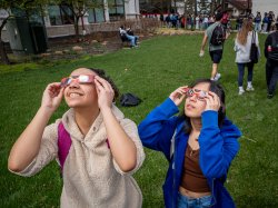 Physics majors Mariana Pereira and Jasmine Valencerina looking cool in their eclipse glasses. [Photo by John LaRosa.]