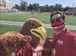 A photo of Montclair State University president Jonathan Koppell with Rocky the Red Hawk