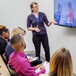 Image of a faculty member in the Psychology Services Clinic showing students a technique for assessment