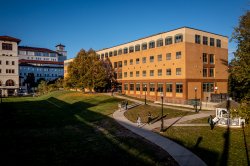 dickson hall illuminated by setting sun. people are walking on the paths