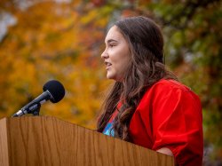 Brianna Dagostino ’21 speaking at podium for Indigenous Peoples Day.
