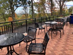 The outside patio of Stone Hall with table and chairs and a view of the New York skyline.