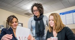 Three staff members of RYTE Institute looking at document.