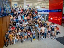 group of students pose on stairs and seating