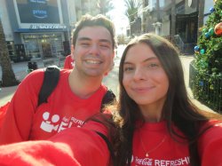 Two students in red shirts smiling in a selfie-style photo.