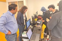 students working in computer lab with faculty