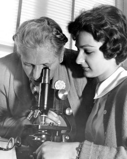 Black and white photo of S Marie Kuhnen using microscope