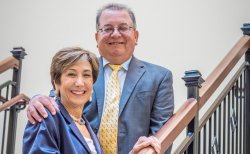 Mimi and Edwin Feliciano on stairs in the new Feliciano School of Business.