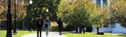 Students walking with college hall in the background