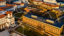 aerial view of campus as sun shines and sets on buildings