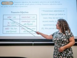 "A woman points to a screen with Spanish adjectives on it."