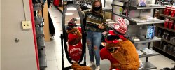 Rocky the Red Hawk trying on several Montclair State hats at the Bookstore.