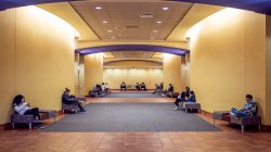 Photo inside University Hall of a few people sitting in the hallway.