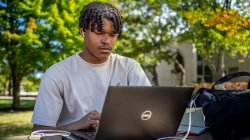 Man sitting at computer outside