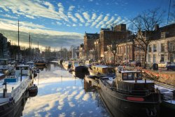Ships and boats in a canal in Groningen, Noorderhaven, on a cold day in winter.