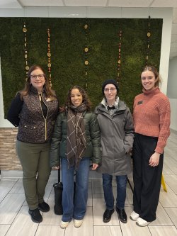Photo of (left to right) Jennifer Bostedo, Michelle Bradley, Adeline Cochran, and Jessica ___ standing in front of a moss wall in Freeman Dining Hall.