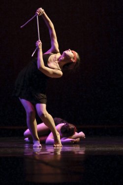 Photo of two dancers, one upright, one on floor.