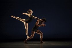 Photo of male and female dancers, one in a leaping pose.