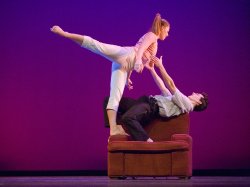 Photo of dancers in dramatic pose on a recliner chair.