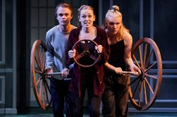 Image of 3 students on stage holding wheels