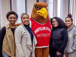Four students pose with Rocky the Red Hawk at University College's Signing Day event in April 2019