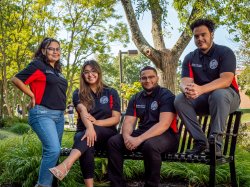 The four executive board members of the Student Government Association on an outdoor bench
