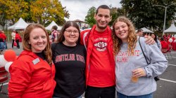 alumni and staff pose for photo at homecoming
