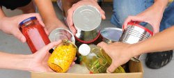 Picture of people putting canned products in a box.