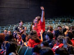student standing with fist raised at EOF
