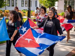 students and faculty walking on campus holding flags