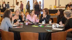 women in business attire at conference table in university conference center