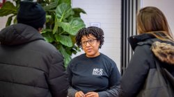 A woman talks with two students.