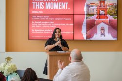 Jane Sanchez Swain stands behind a lectern holding a microphone.