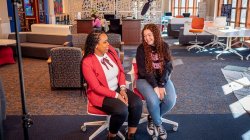 two people sitting in chairs talking