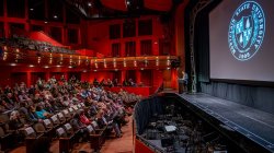 faculty and staff seated in Kasser Theater as President Koppell speaks on stage