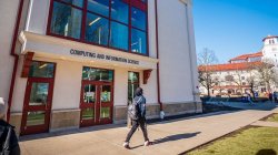Student walking past the entrance of the Center for Computing and Information Science