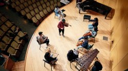 Male violinist leads group playing string instruments.