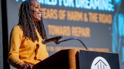 Bettina L. Love smiles as she speaks at a podium.