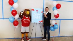 Rocky and a man standing in front of a sign that reads "Future Home of Saxbys"