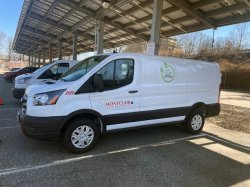 Photo of the driver's side of the new electric van #269 parked in lot 61 under the solar panels.