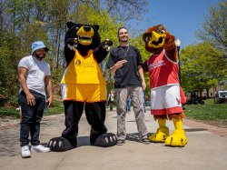 Deacon and Rocky taking a posing for a picture with 2 other people.