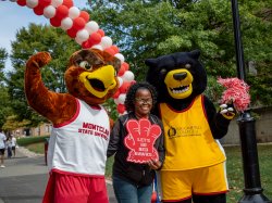 Montclair and Bloomfield Mascots posing with woman for a photo