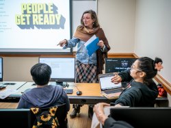 Prof. Freddie Harris lecturing students sitting in front of computers.