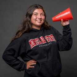 Woman student in black Montclair hooded sweater holding a red megaphone