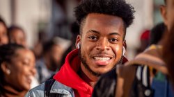 Student wearing white headphones smiling