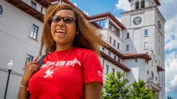 Smiling woman in red-hawk shirt in front of University Hall